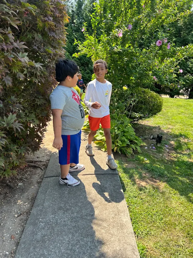 Two boys walking along the garden path outdoors