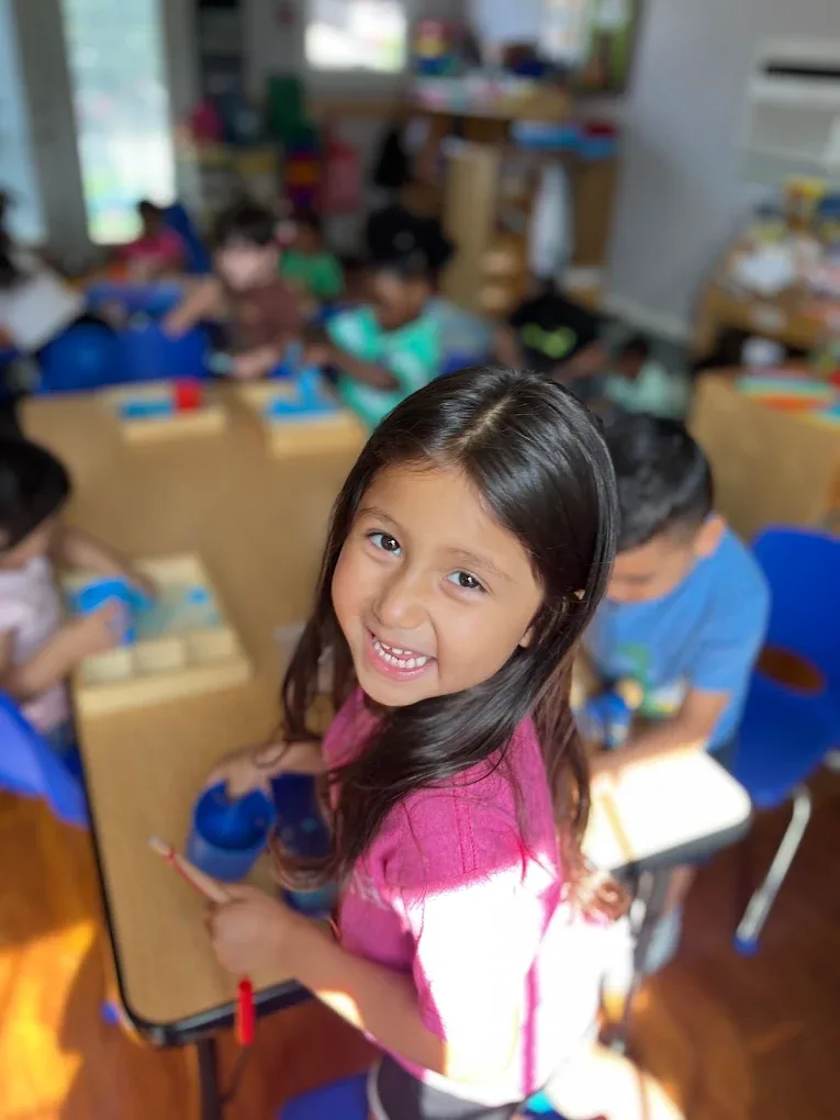 Smiling girl in a pink shirt during an art activity